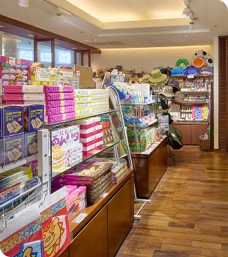 木目調の床が広がる店内に、色鮮やかな沖縄菓子や南国雑貨が並ぶ棚が整然と配置されています。