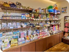 多段の壁面棚に、沖縄菓子やぬいぐるみなどの南国土産が隙間なく並べられています。
