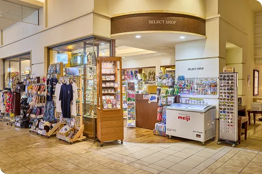 ホテルのセレクトショップ前には、アイス用冷凍庫やサングラス、衣類が並ぶ什器が配置されています。