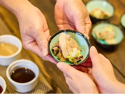 黒いコンロで熱せられる出汁の鍋の横で、薄切りの豚肉と積み上げた野菜が食欲をそそる朝食の膳が並んでいます。